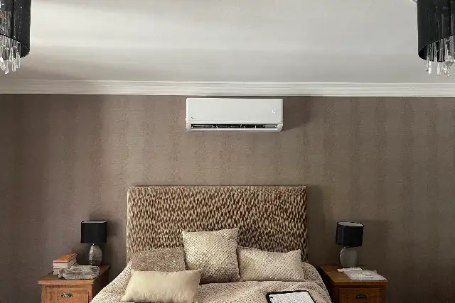 Bedroom air conditioning in Teesside Quiet wall-mounted air conditioning unit installed above the bed in a calm, neutral bedroom