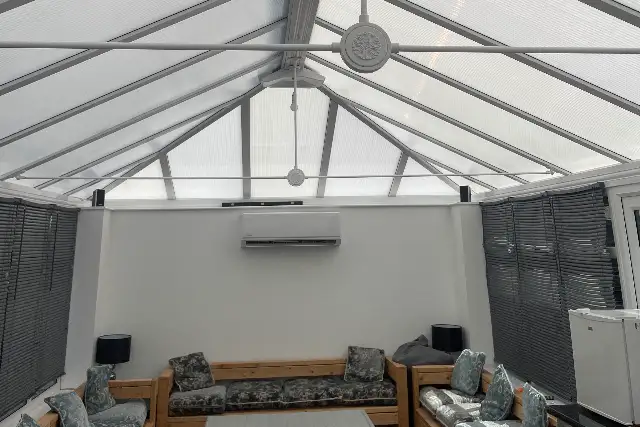 Conservatory air conditioning in Teesside Air conditioning unit installed on the end wall of a glass-roofed conservatory