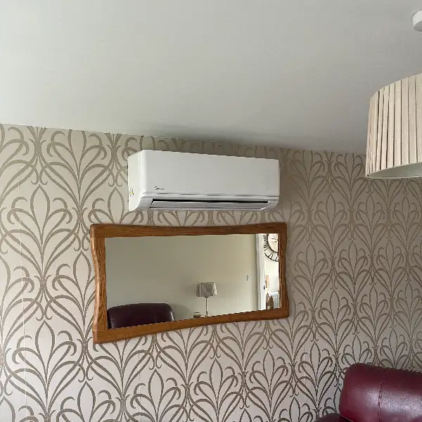 Lounge air conditioning Air conditioning unit installed above a mirror in a lounge with patterned wallpaper