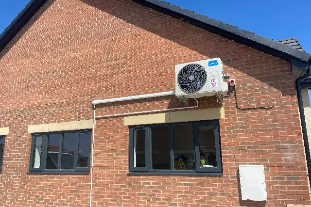 Split system air conditioning in Teesside Split system outdoor unit mounted high on the wall of a brick building