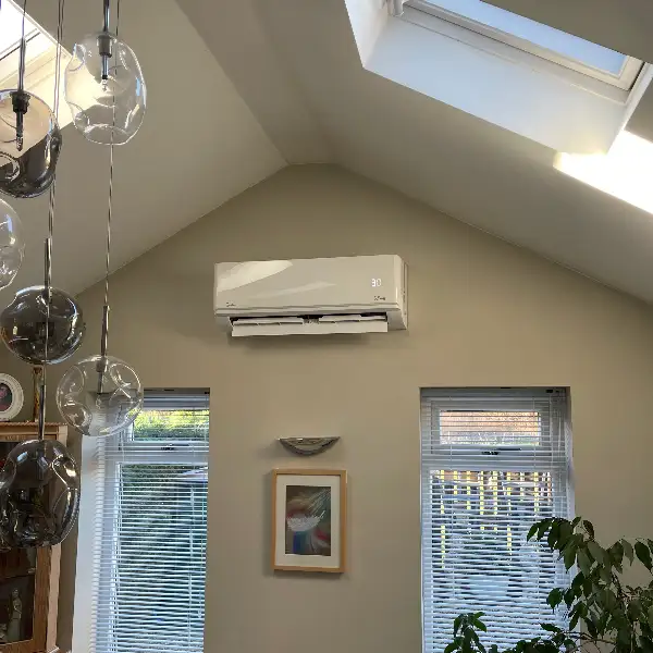 Vaulted living room air conditioning Wall-mounted air conditioning unit in a vaulted living room with a roof window